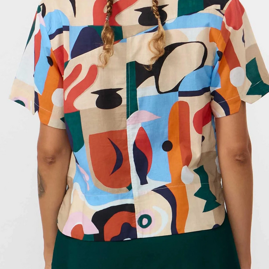 Camisa de manga corta para mujer con estampado Cruise en tonos suaves, corte boxy entallado, cuello de solapas y botones de corozo de la marca Suite13 Lab.
