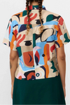 Camisa de manga corta para mujer con estampado Cruise en tonos suaves, corte boxy entallado, cuello de solapas y botones de corozo de la marca Suite13 Lab.