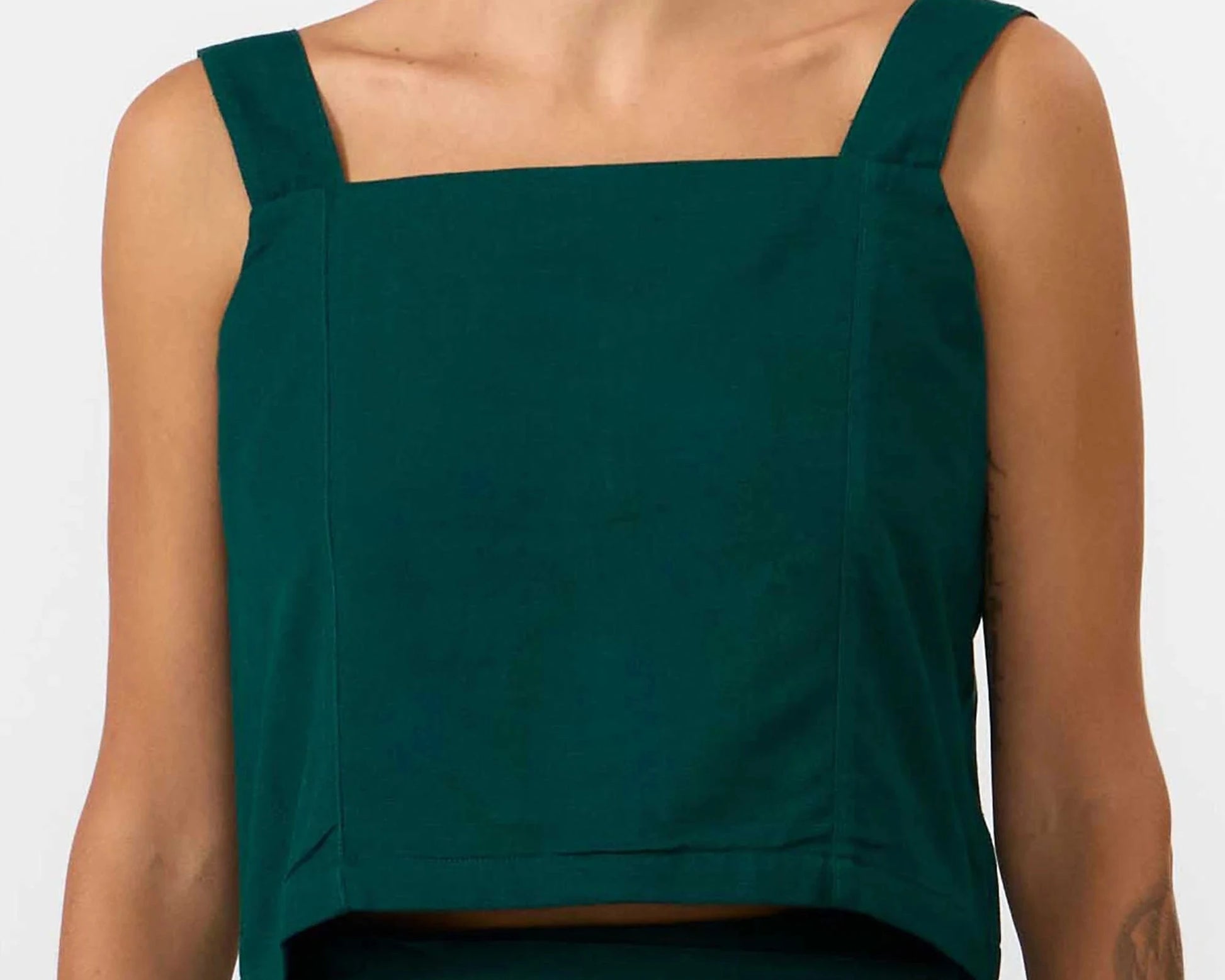Top corto de color verde oscuro con escote recto, tirantes finos ajustables y cierre trasero de botones naturales, confeccionado en mezcla de algodón y lino.
