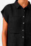 Camisa de manga corta en color negro con caída fluida, confeccionada en mezcla de lino y viscosa sostenible, con cuello clásico y botones frontales de tono natural.