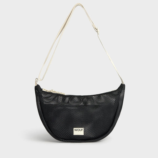 Bolso bandolera de color negro puro, de diseño estructurado con correa cruzada ajustable de algodón, cremallera superior y etiqueta de silicona, modelo Onyx de Wouf.