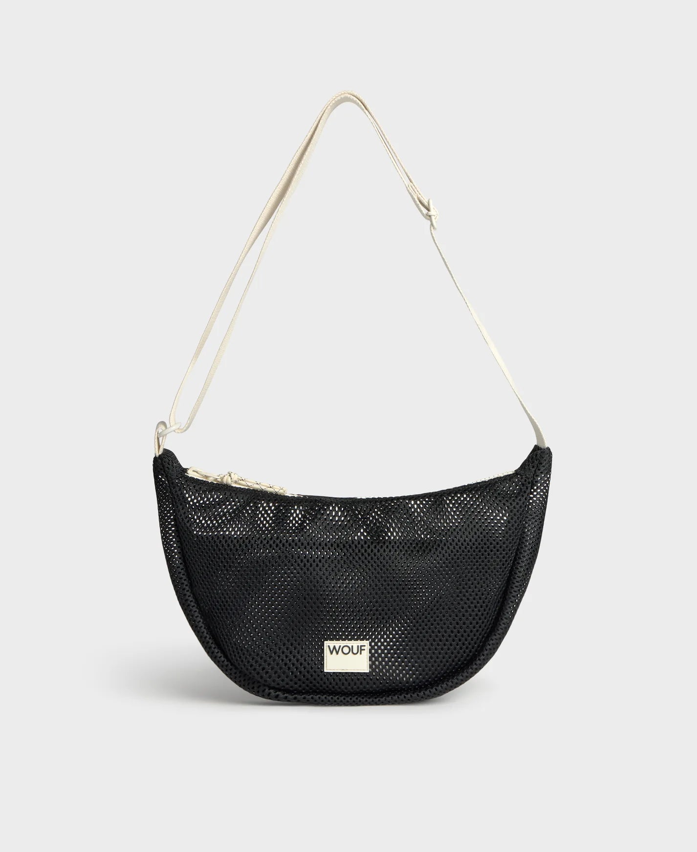 Bolso bandolera de color negro puro, de diseño estructurado con correa cruzada ajustable de algodón, cremallera superior y etiqueta de silicona, modelo Onyx de Wouf.