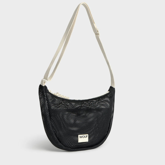 Bolso bandolera de color negro puro, de diseño estructurado con correa cruzada ajustable de algodón, cremallera superior y etiqueta de silicona, modelo Onyx de Wouf.