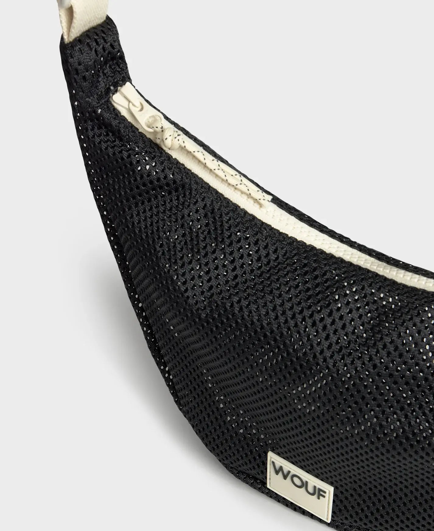 Bolso bandolera de color negro puro, de diseño estructurado con correa cruzada ajustable de algodón, cremallera superior y etiqueta de silicona, modelo Onyx de Wouf.