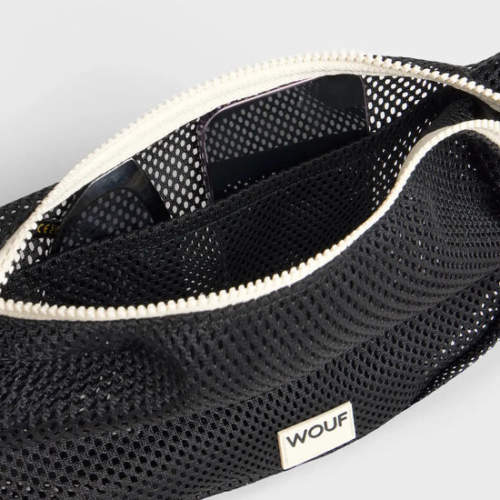 Bolso bandolera de color negro puro, de diseño estructurado con correa cruzada ajustable de algodón, cremallera superior y etiqueta de silicona, modelo Onyx de Wouf.