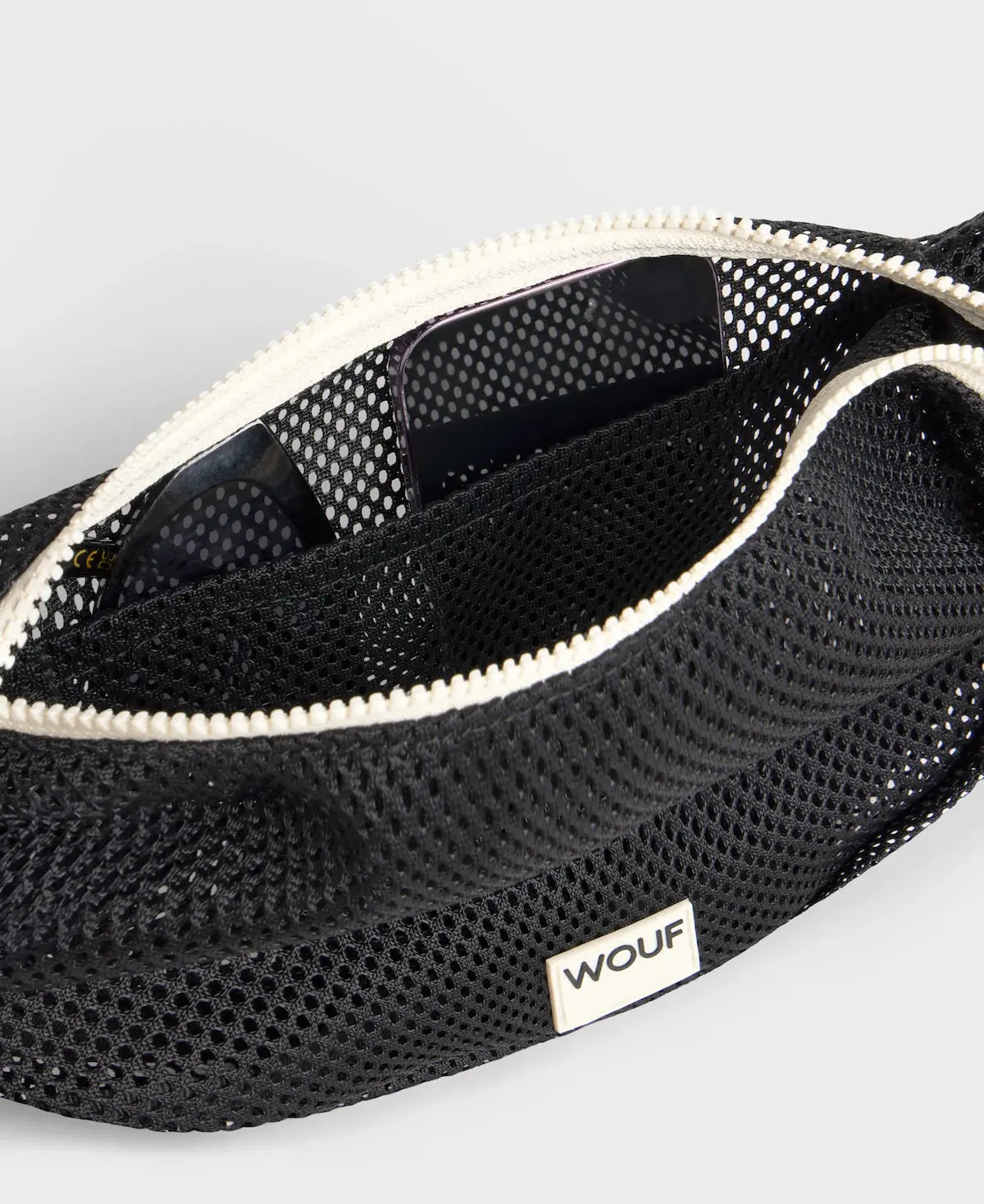 Bolso bandolera de color negro puro, de diseño estructurado con correa cruzada ajustable de algodón, cremallera superior y etiqueta de silicona, modelo Onyx de Wouf.