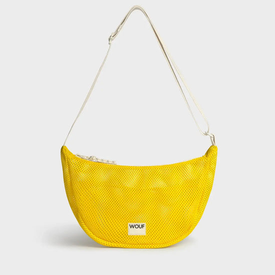 Bolso bandolera de color amarillo en tejido de rejilla (mesh) con correa cruzada ajustable de algodón, cremallera superior y etiqueta frontal de silicona, modelo Ray de Wouf.