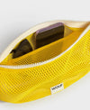 Bolso bandolera de color amarillo en tejido de rejilla (mesh) con correa cruzada ajustable de algodón, cremallera superior y etiqueta frontal de silicona, modelo Ray de Wouf.