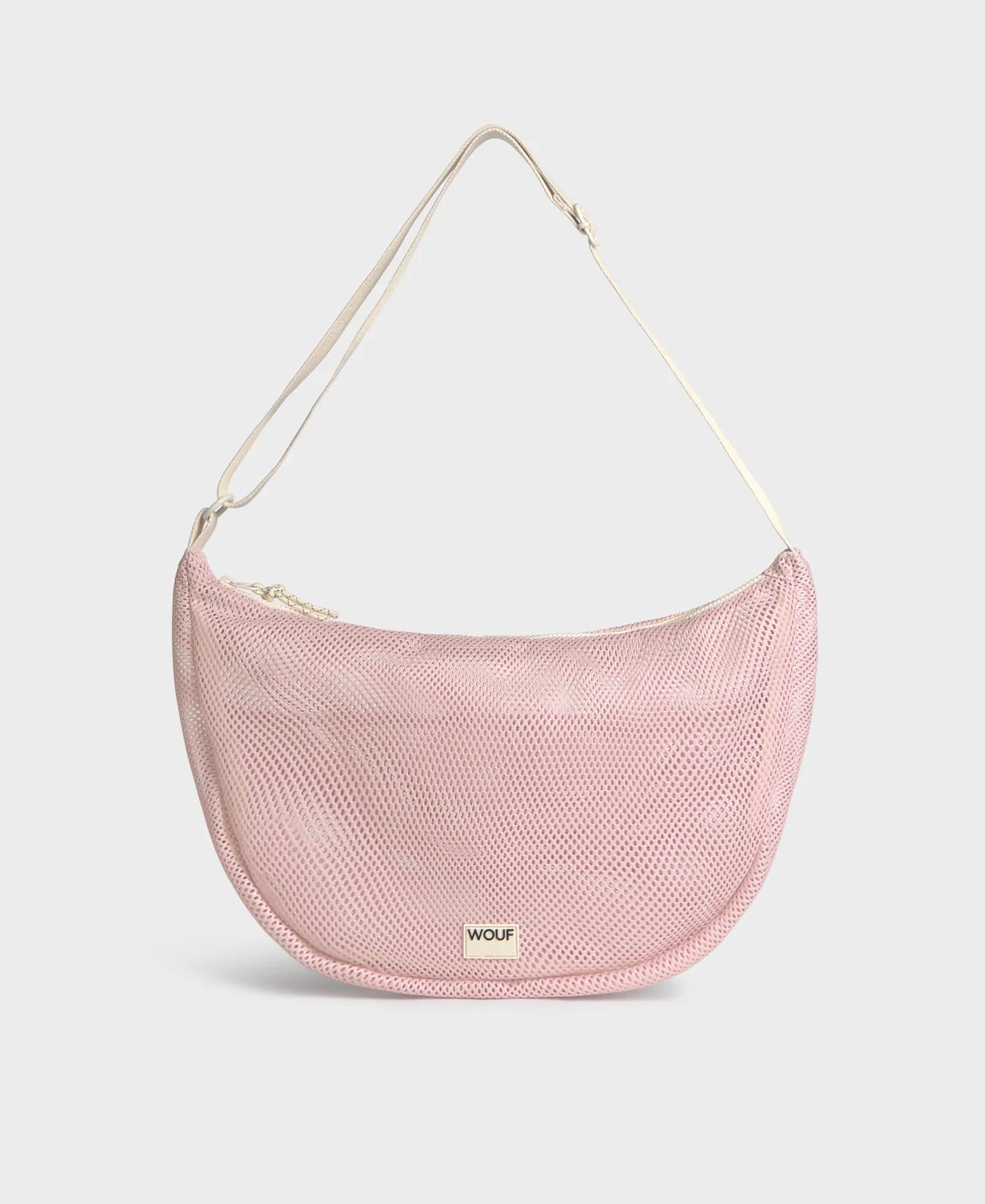 Bolso cruzado de gran tamaño color rosa empolvado en tejido de rejilla (mesh) con correa ajustable de algodón, cremallera superior y bolsillos interiores, marca Wouf.