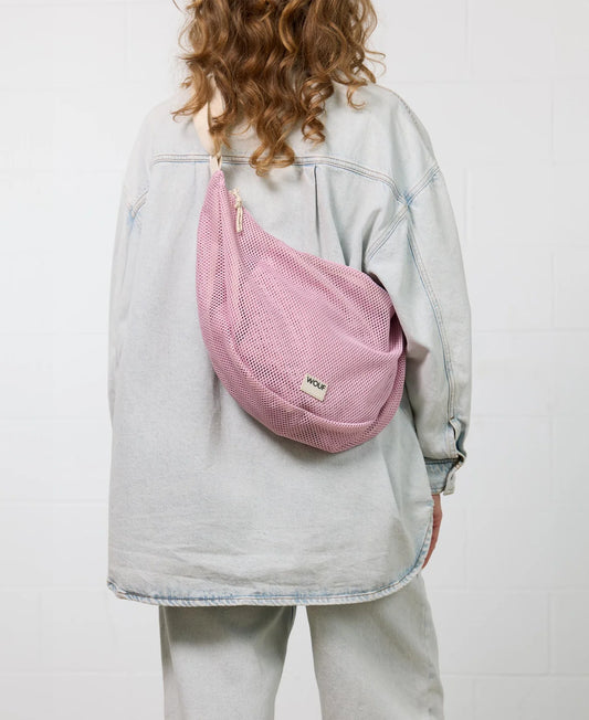 Bolso cruzado de gran tamaño color rosa empolvado en tejido de rejilla (mesh) con correa ajustable de algodón, cremallera superior y bolsillos interiores, marca Wouf.