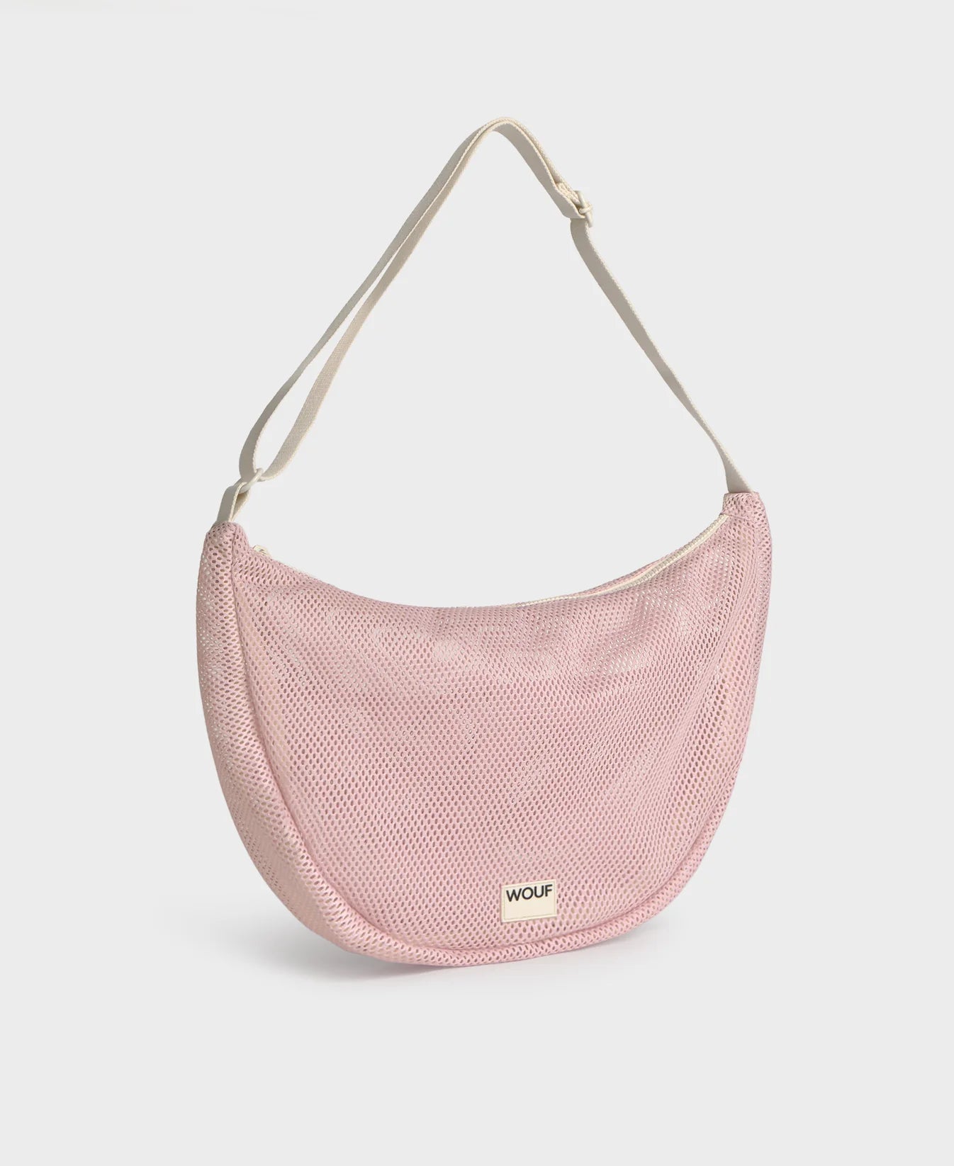 Bolso cruzado de gran tamaño color rosa empolvado en tejido de rejilla (mesh) con correa ajustable de algodón, cremallera superior y bolsillos interiores, marca Wouf.