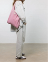 Bolso grande tipo camiseta de color rosa empolvado en tejido de rejilla (mesh) con asas integradas y etiqueta frontal de silicona, marca Wouf.