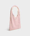 Bolso grande tipo camiseta de color rosa empolvado en tejido de rejilla (mesh) con asas integradas y etiqueta frontal de silicona, marca Wouf.