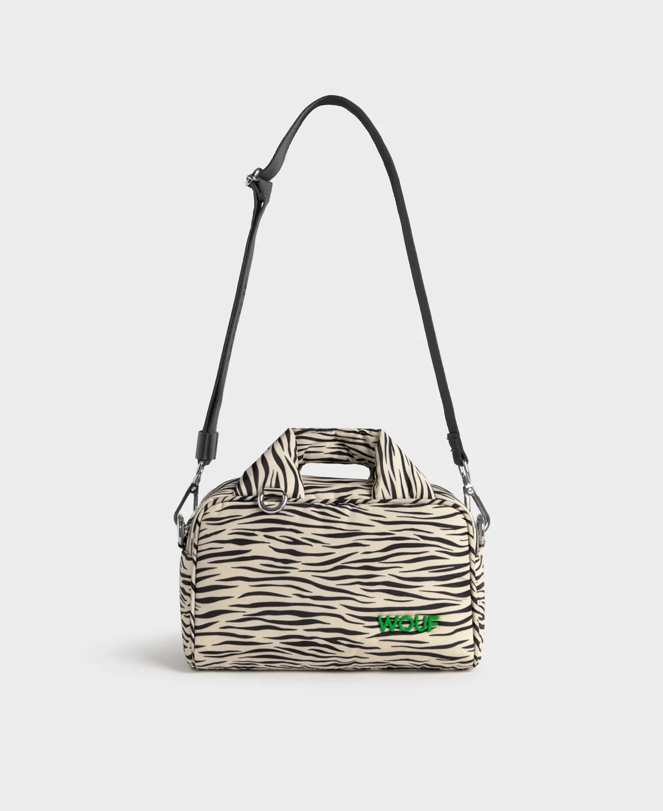Bolso tipo bowling con estampado animal print de cebra, logo metálico frontal, asas cortas acolchadas y correa larga extraíble, modelo Zebra Hit de Wouf.