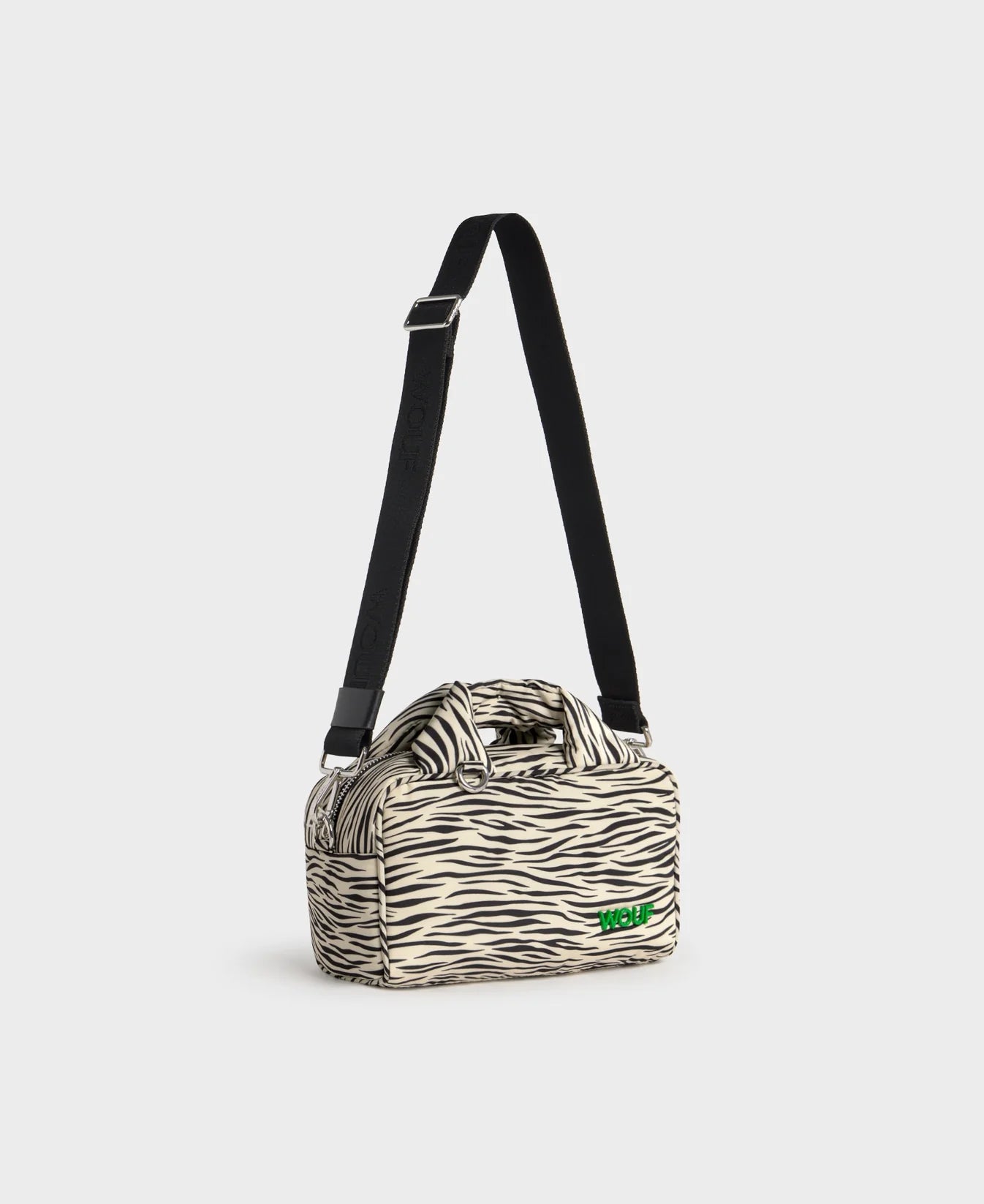 Bolso tipo bowling con estampado animal print de cebra, logo metálico frontal, asas cortas acolchadas y correa larga extraíble, modelo Zebra Hit de Wouf.