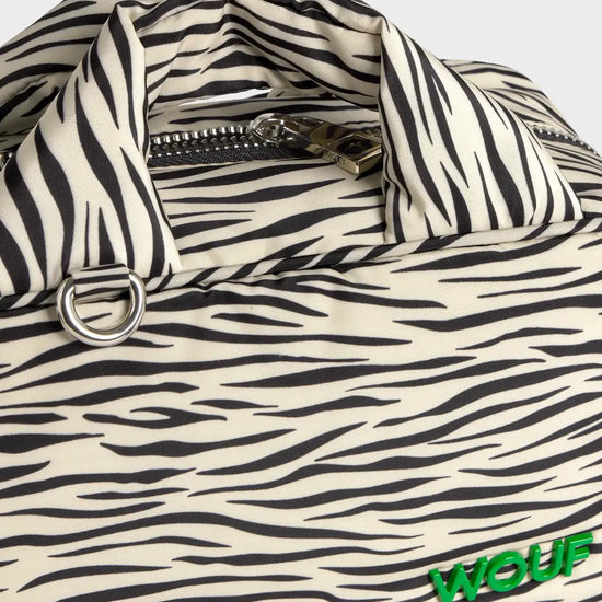 Bolso tipo bowling con estampado animal print de cebra, logo metálico frontal, asas cortas acolchadas y correa larga extraíble, modelo Zebra Hit de Wouf.