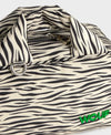 Bolso tipo bowling con estampado animal print de cebra, logo metálico frontal, asas cortas acolchadas y correa larga extraíble, modelo Zebra Hit de Wouf.