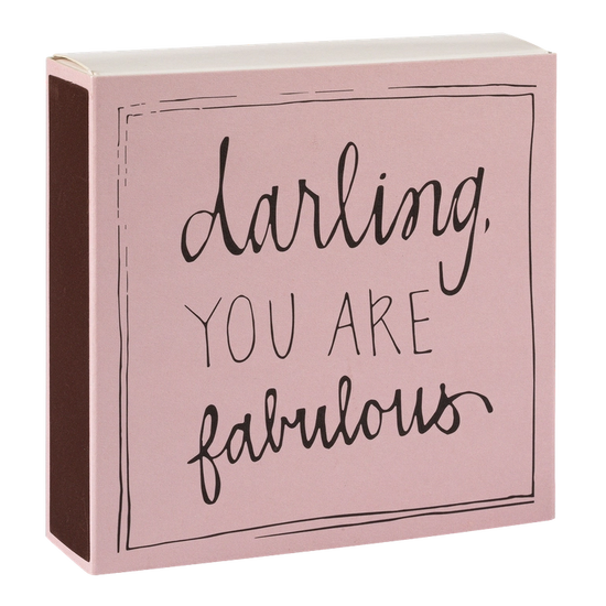 Caja de cerillas cuadrada de color rosa con el texto 'Darling you are fabulous' impreso, que contiene 125 cerillas largas de madera negra y punta blanca.
