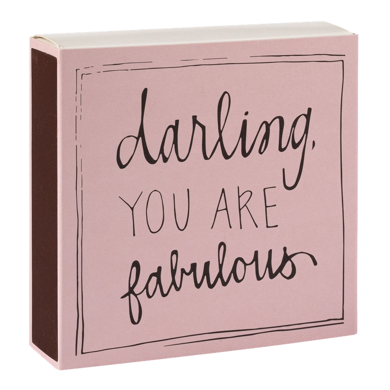 Caja de cerillas cuadrada de color rosa con el texto 'Darling you are fabulous' impreso, que contiene 125 cerillas largas de madera negra y punta blanca.