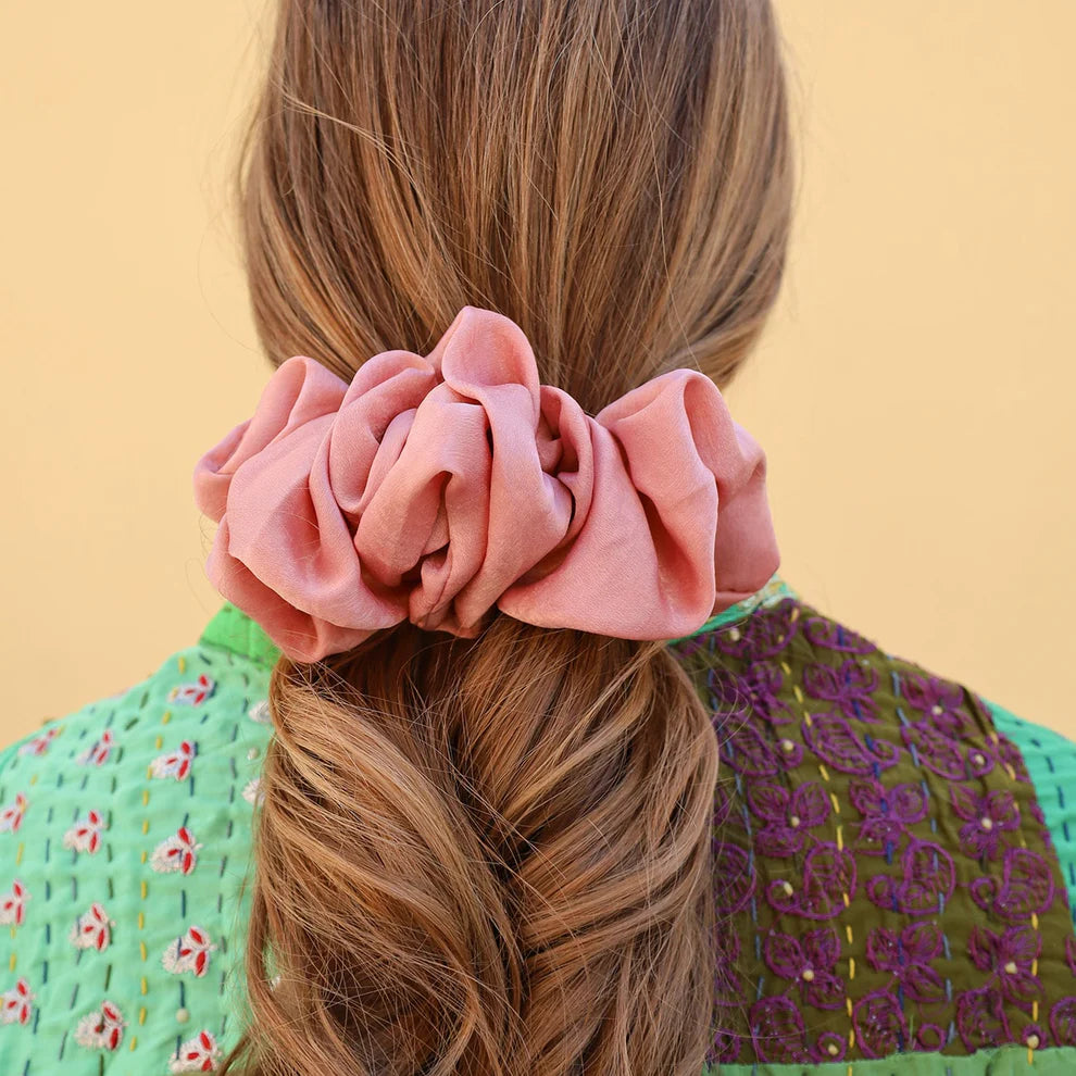 Coletero tipo scrunchie de satén plisado en color rosa antiguo con acabado brillante y diseño ondulado de la marca danesa By Stær.