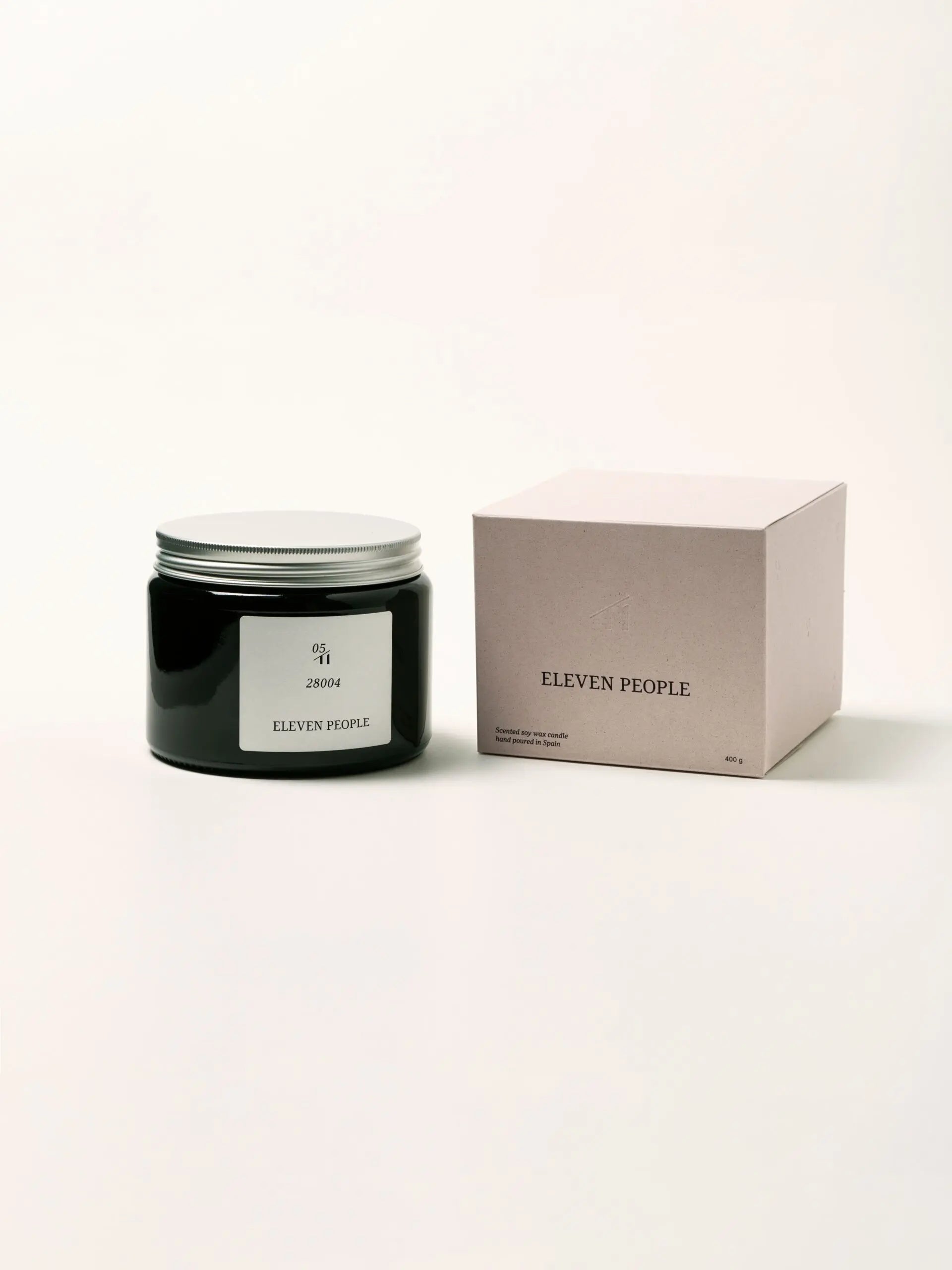 Vela aromática en envase de vidrio ámbar, colección 05 28004 de Eleven People, fragancia grosella negra abedul y musgo de roble, elaborada artesanalmente en Asturias