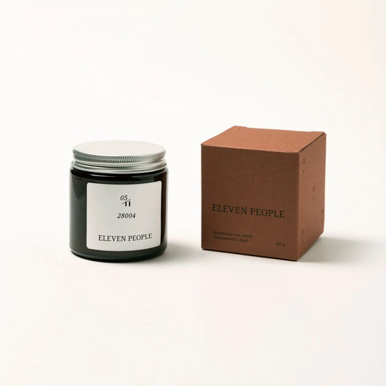 Vela aromática en envase de vidrio ámbar, colección 05 28004 de Eleven People, fragancia grosella negra abedul y musgo de roble, elaborada artesanalmente en Asturias
