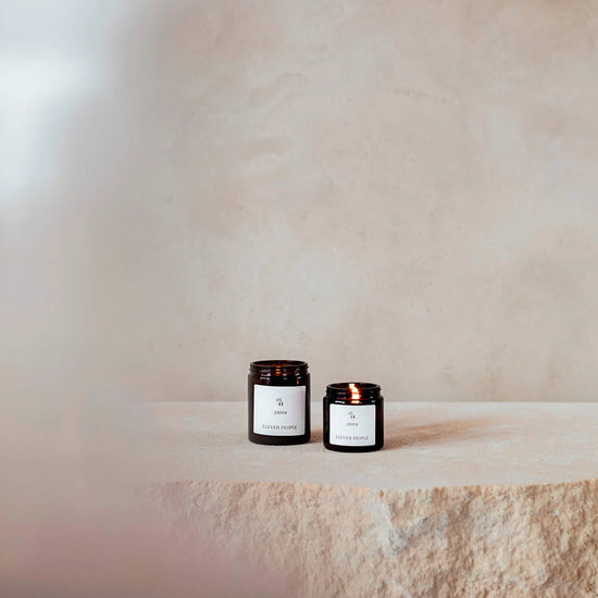 Vela aromática en envase de vidrio ámbar, colección 05 28004 de Eleven People, fragancia grosella negra abedul y musgo de roble, elaborada artesanalmente en Asturias